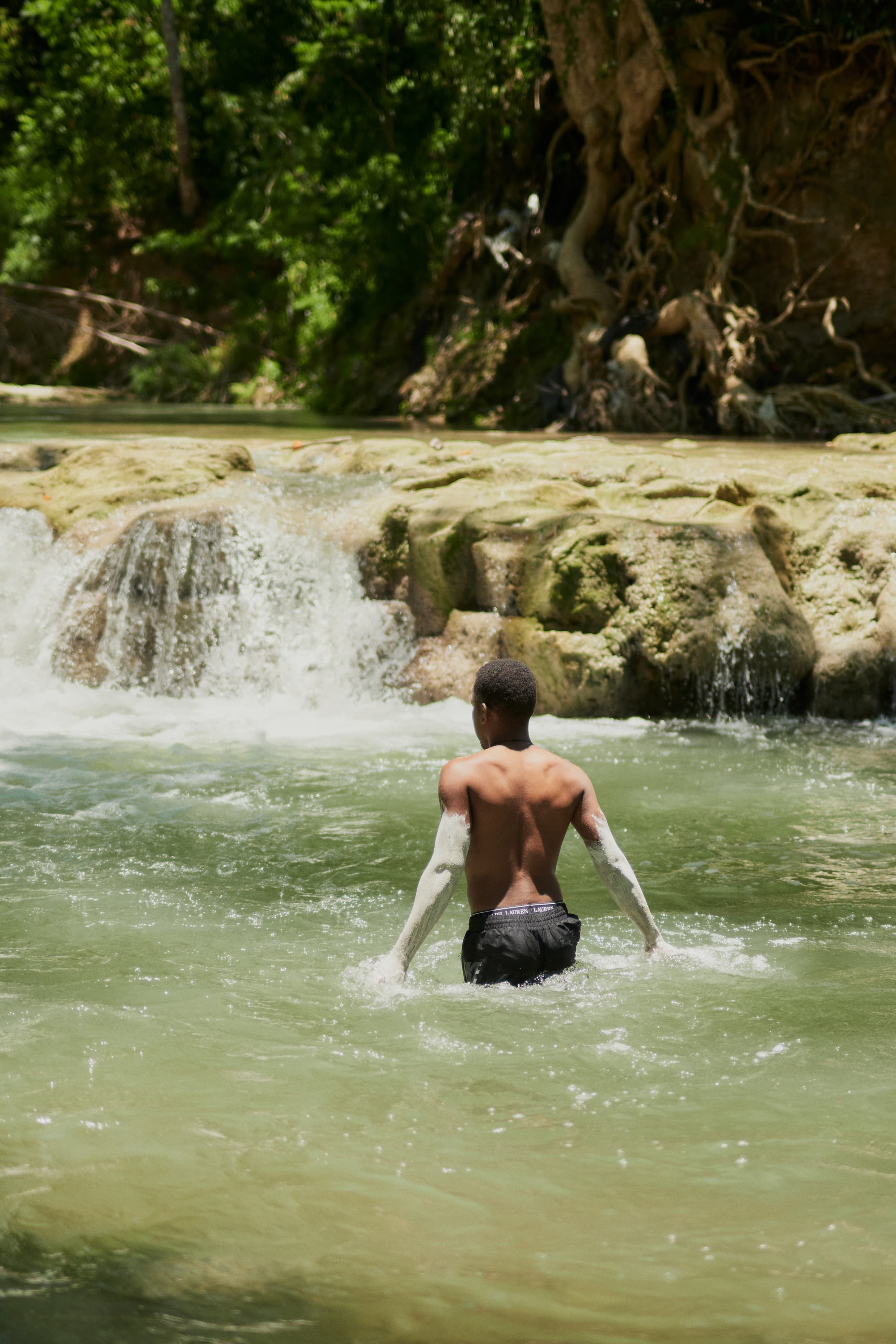 Wading toward a waterfall at Dunn's River, Jamaica